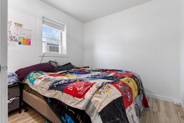 bedroom with light wood-type flooring and cooling unit