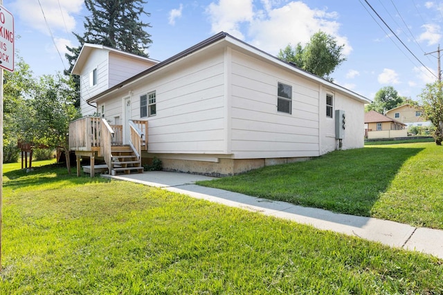 back of house featuring a wooden deck and a lawn