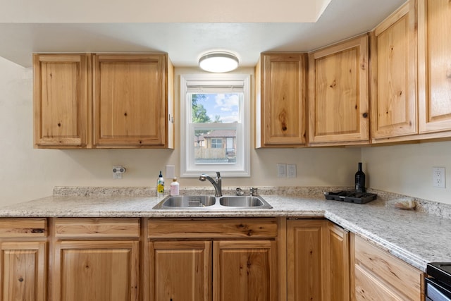 kitchen with sink, light stone counters, and range