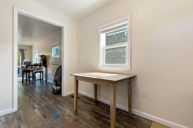 corridor with dark hardwood / wood-style flooring and plenty of natural light