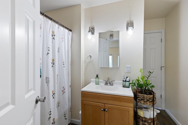 bathroom with curtained shower, vanity, and toilet