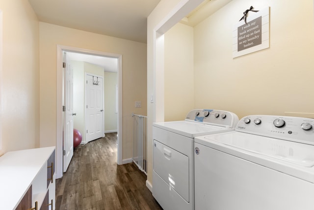 clothes washing area featuring dark hardwood / wood-style floors and washer and clothes dryer