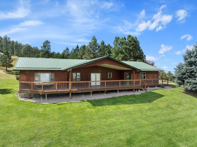 back of property featuring a wooden deck and a lawn