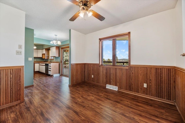 empty room with a textured ceiling, ceiling fan with notable chandelier, sink, and dark hardwood / wood-style floors