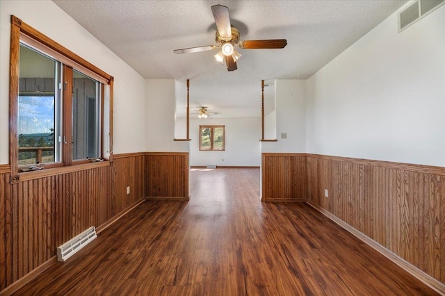 empty room featuring dark hardwood / wood-style flooring, a textured ceiling, and ceiling fan