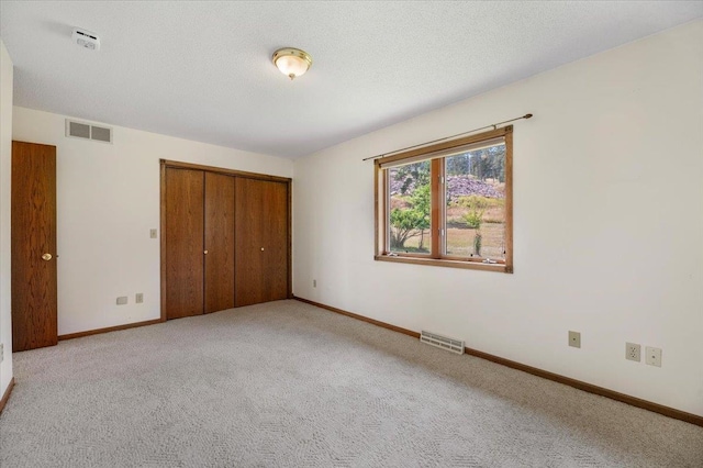 unfurnished bedroom with a closet and light carpet