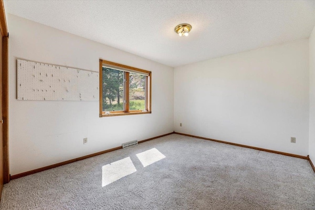 spare room with a textured ceiling and carpet floors