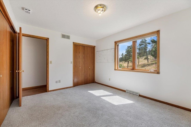 unfurnished bedroom with a textured ceiling and carpet