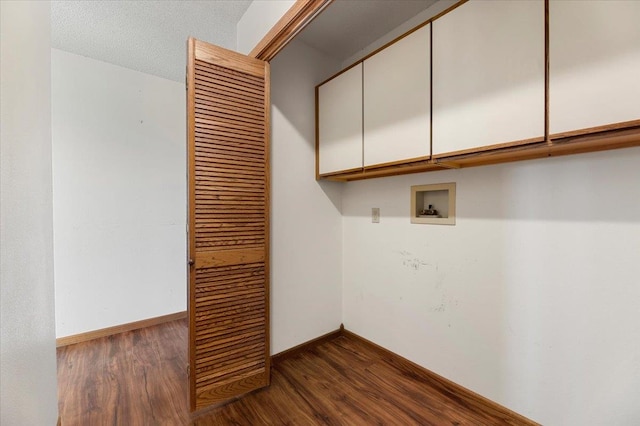 laundry area featuring a textured ceiling, dark hardwood / wood-style floors, hookup for a washing machine, and cabinets