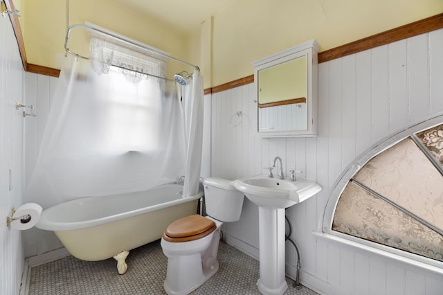 bathroom with toilet, shower / tub combo with curtain, and tile patterned floors