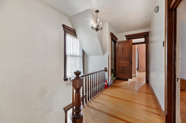 corridor with a notable chandelier and light hardwood / wood-style flooring