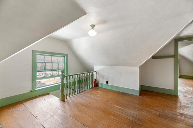 additional living space featuring lofted ceiling and hardwood / wood-style floors