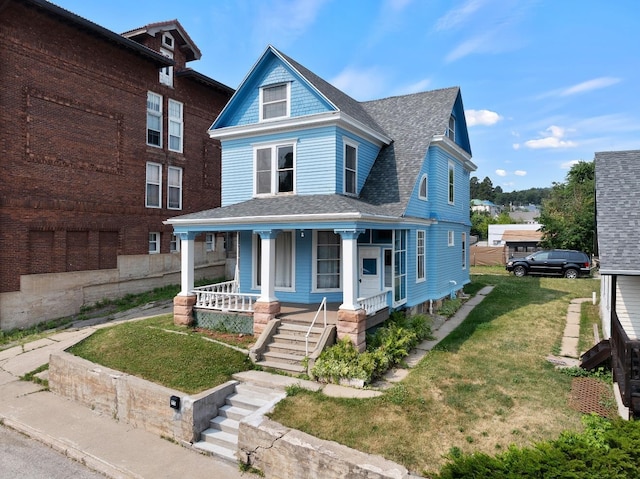 victorian-style house featuring a porch and a front yard