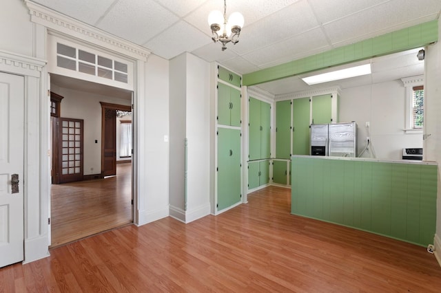 interior space featuring hardwood / wood-style floors, stainless steel fridge, a paneled ceiling, and a notable chandelier