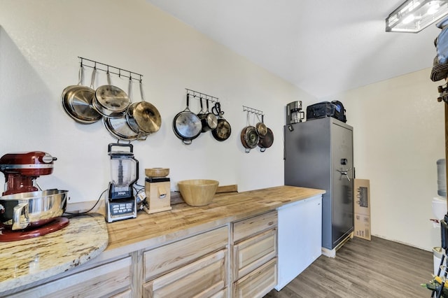 kitchen with butcher block countertops, wood finished floors, and freestanding refrigerator