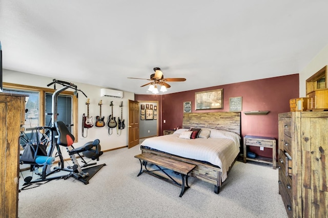 bedroom with baseboards, a ceiling fan, an accent wall, a wall mounted air conditioner, and carpet