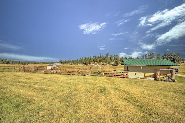 view of yard with fence and a rural view