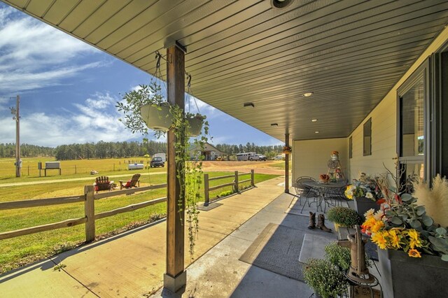 kitchen featuring a barn door, appliances with stainless steel finishes, light stone counters, track lighting, and wood-type flooring