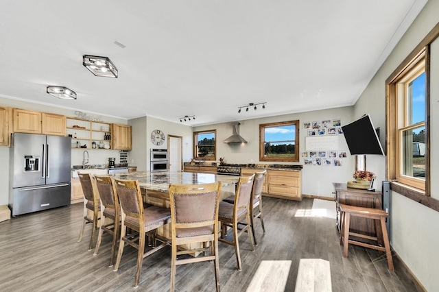 dining area with track lighting, dark wood-type flooring, and sink