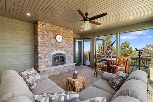 carpeted living room featuring ceiling fan, wooden ceiling, and a fireplace