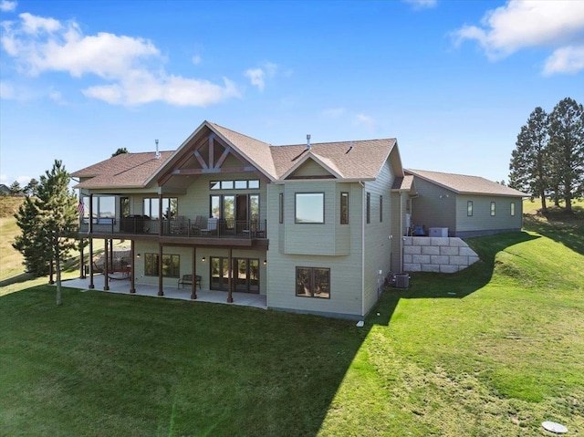 back of property featuring a balcony, central air condition unit, a lawn, and a patio area