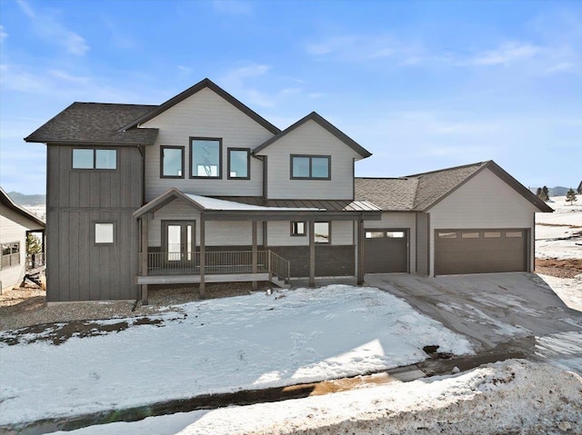 view of front of property with board and batten siding, covered porch, driveway, and an attached garage