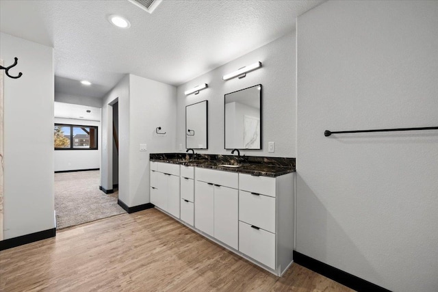 bathroom featuring vanity, hardwood / wood-style floors, and a textured ceiling