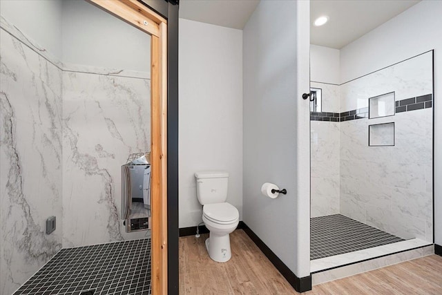 bathroom featuring tiled shower, wood-type flooring, and toilet