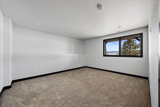 spare room with carpet floors and a textured ceiling