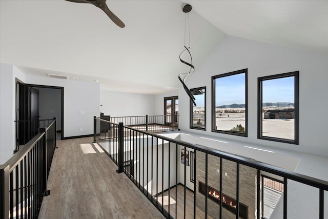 hallway with wood-type flooring, a mountain view, and high vaulted ceiling