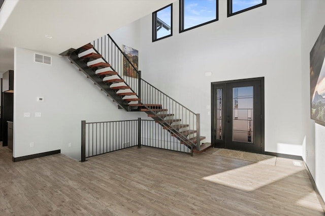 entrance foyer with hardwood / wood-style floors and a high ceiling