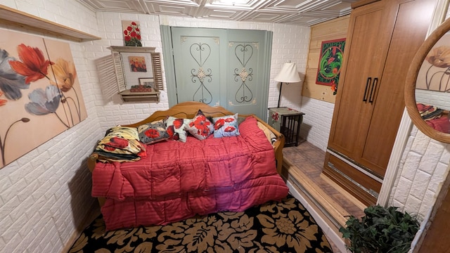 bedroom featuring brick wall