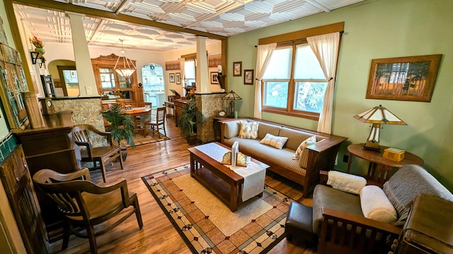 living room featuring coffered ceiling, hardwood / wood-style flooring, and ornate columns