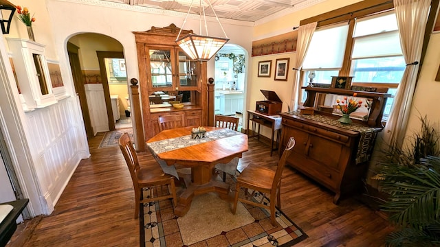 dining space with ornamental molding and dark hardwood / wood-style floors