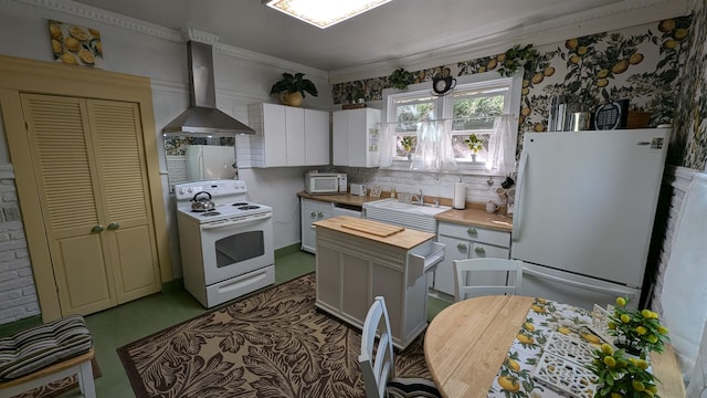 kitchen with crown molding, white appliances, white cabinetry, wall chimney range hood, and decorative backsplash