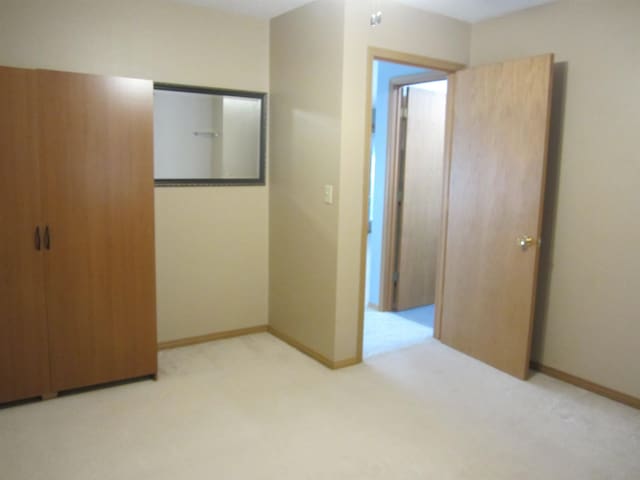 unfurnished bedroom with baseboards and carpet floors