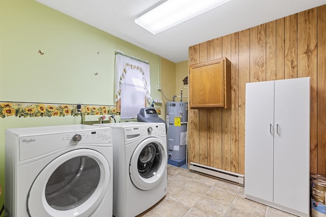 clothes washing area with washing machine and clothes dryer, a baseboard radiator, light tile patterned flooring, cabinet space, and electric water heater