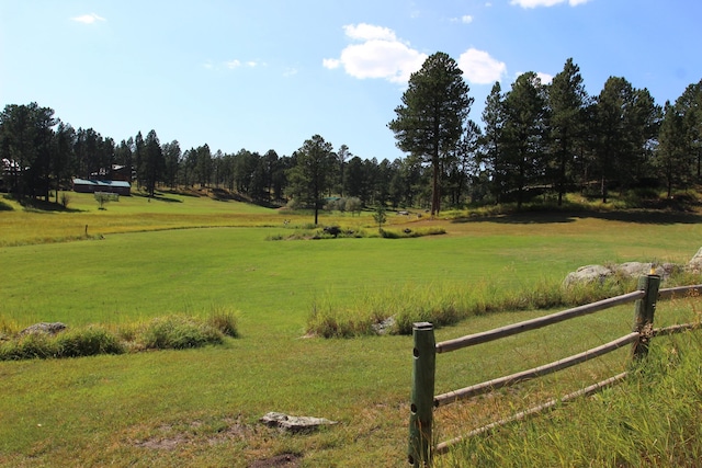 view of property's community featuring a lawn and a rural view