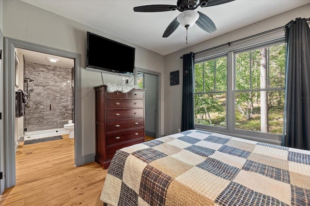 bedroom with a ceiling fan, connected bathroom, and light wood-style flooring