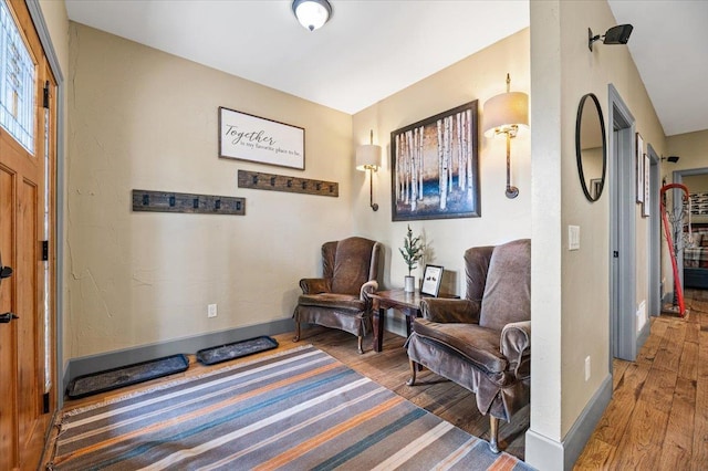 living area featuring baseboards and wood finished floors