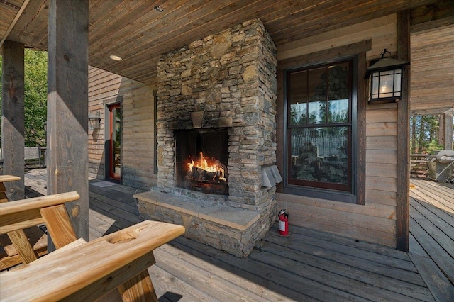 wooden deck featuring an outdoor stone fireplace