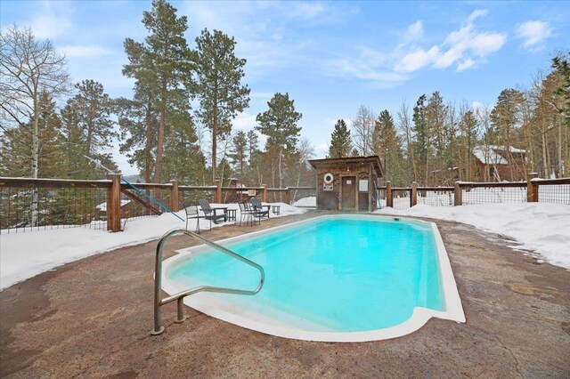 snow covered pool featuring a patio area