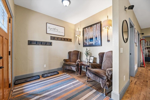 sitting room with dark wood-type flooring and vaulted ceiling