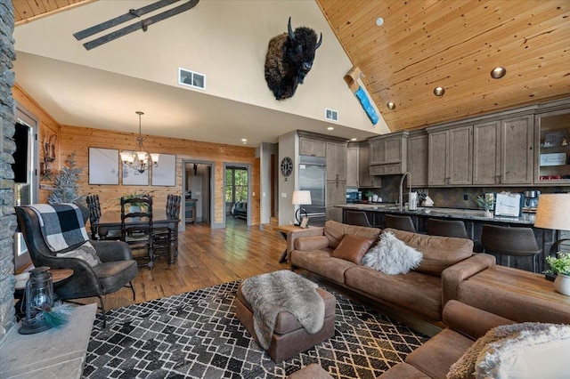 living area featuring wood ceiling, visible vents, a notable chandelier, and wood finished floors