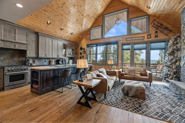 living room featuring hardwood / wood-style flooring, french doors, wood ceiling, sink, and high vaulted ceiling