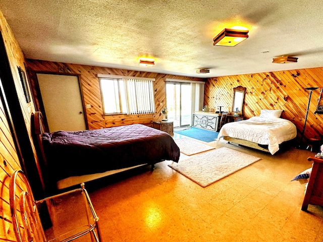 bedroom featuring a textured ceiling and wood walls