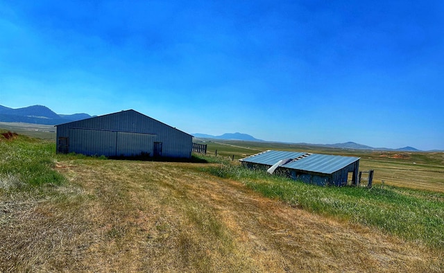 view of yard with a mountain view and a rural view