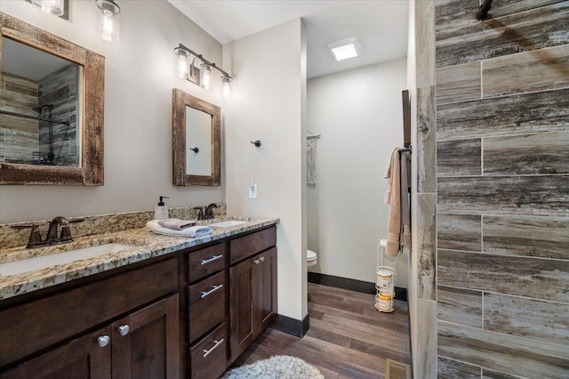 bathroom with vanity, toilet, hardwood / wood-style flooring, and walk in shower