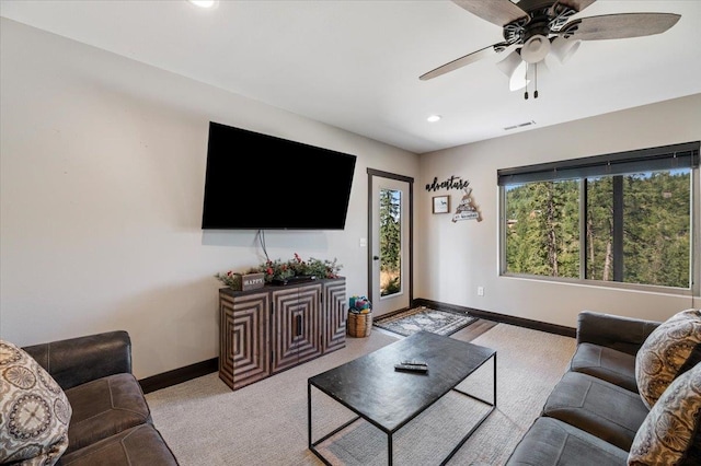 carpeted living room with ceiling fan