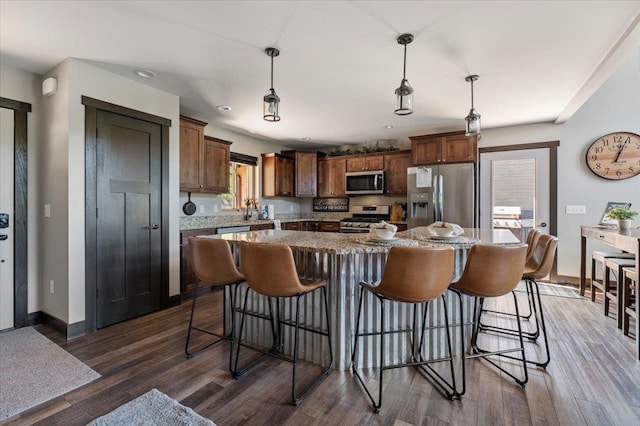 21185 Lost Camp Trl, Lead, SD 57754 - kitchen featuring dark wood-style floors, decorative light fixtures, appliances with stainless steel finishes, and a kitchen island